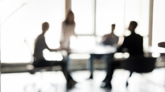 Blurred silhouettes of people participate in business meeting or collaborative discussion